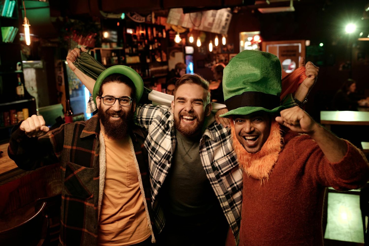 Drei Männer feiern in einem Pub den St. Patrick's Day